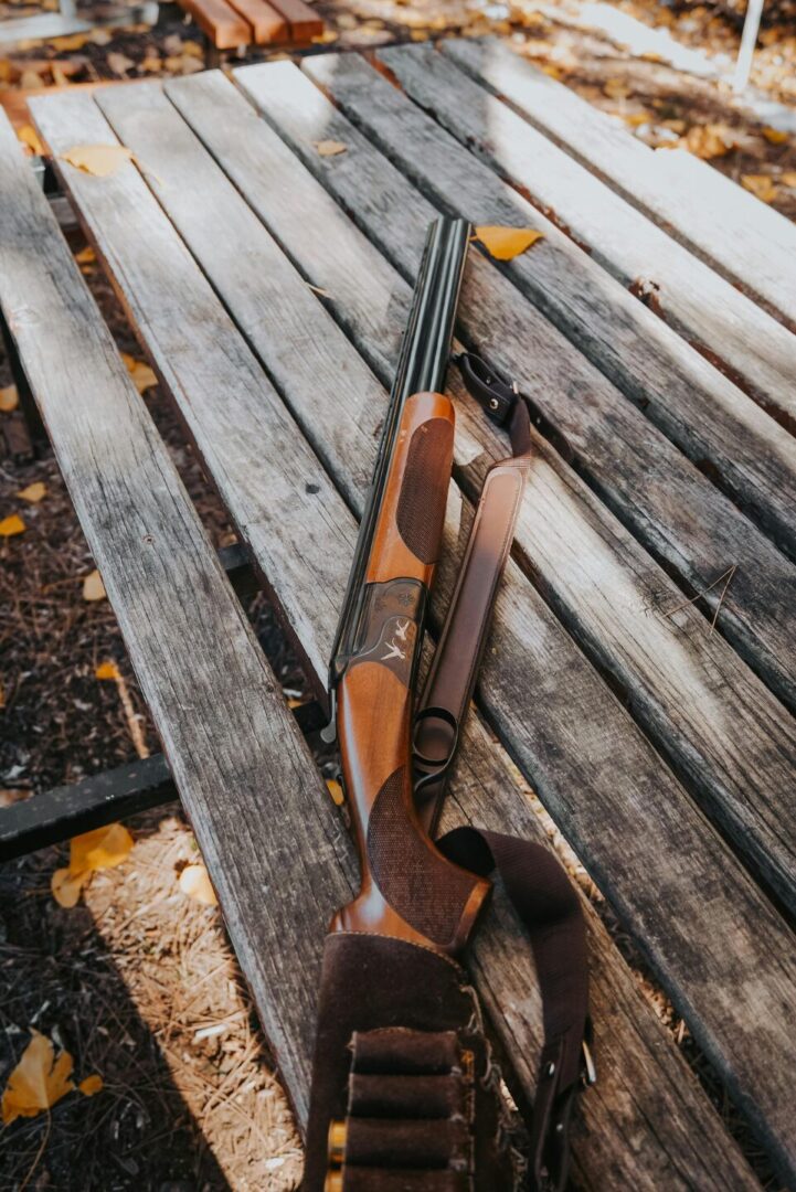 Hunting shotgun on wooden bench outdoors