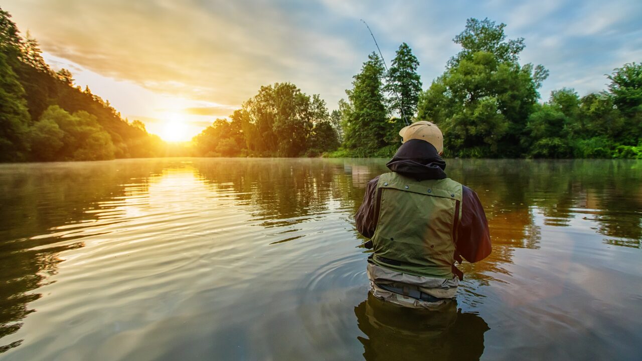 Sport fisherman casting line into water